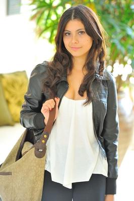 CHICA SEXY CON PANTALONES SKINNY DE CUERO AJUSTADOS Y BOTAS DE TACÓN ALTO