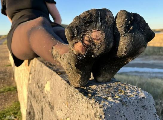 Torn and dirty feet in pantyhose outdoor