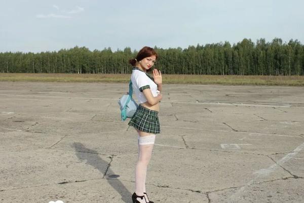 Incredible mom in a schoolgirl outfit posing outdoors