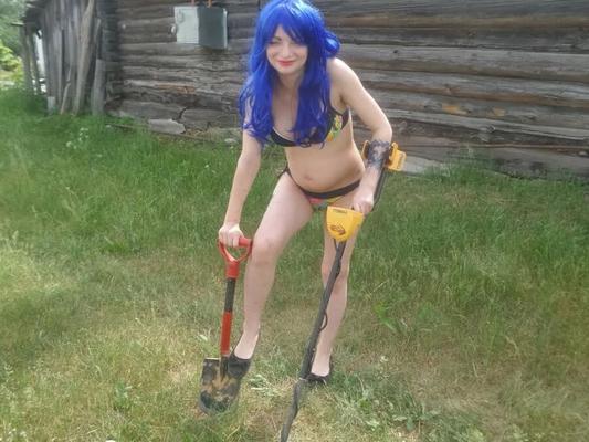 Blue-haired beauty showing her bust while gardening