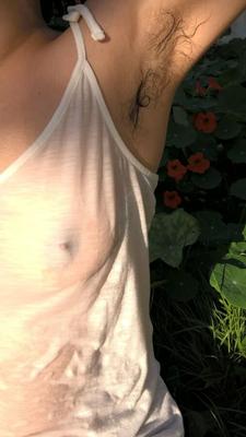 庭で濡れたTシャツを着た私の美しい毛むくじゃらの妻