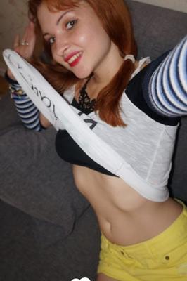 Redhead lifts her shirt to show her tits