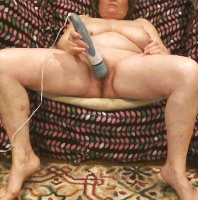 Mom plays with her vibrator in a big chair