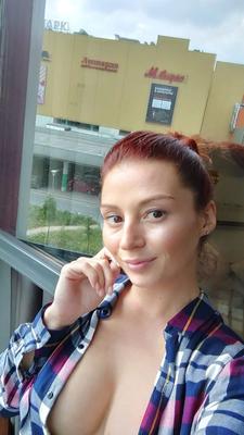 Naughty redhead reveals her big tits on cam