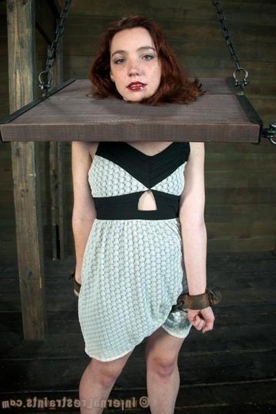16P Maggie Mead bound in wooden stock her shaved pussy vibrated