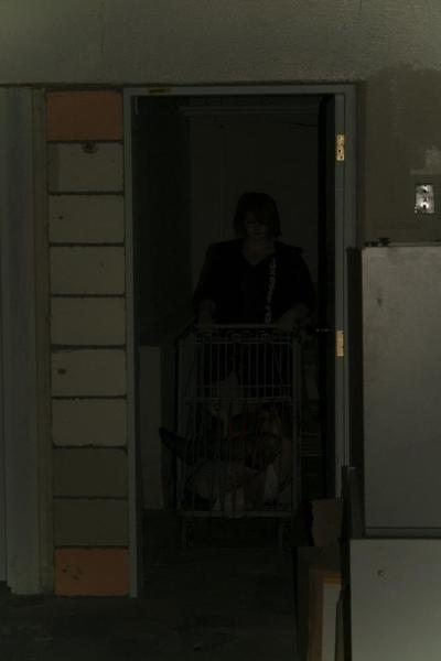 16P Marcy is tied tight into a tiny little cage on wheels.