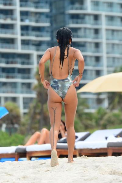 16P Karrueche Tran montre ses seins et ses fesses dans un petit maillot de bain camouflage à la plage.