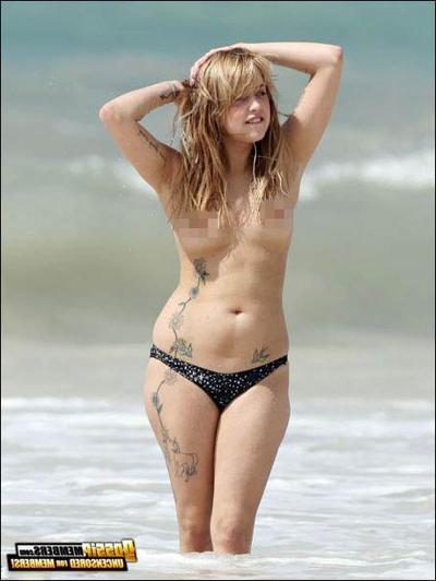 15P Le mannequin Peaches Geldof surprise seins nus sur la plage.