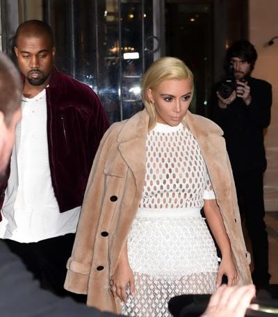 16P Kim Kardashian in a white mesh dress leaving her hotel in Paris