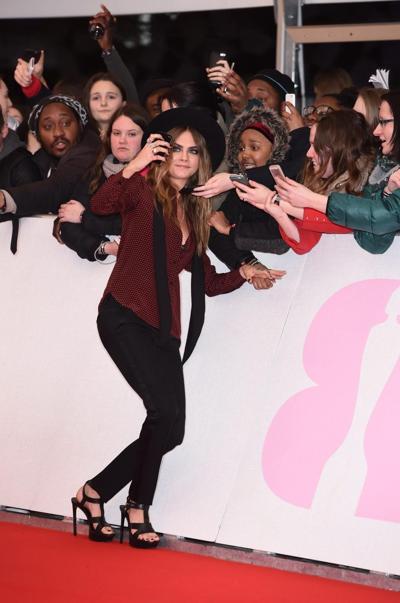 16P Cara Delevingne bra peek at the Brit Awards in London
