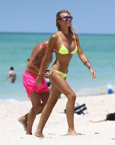 16P Laura Cremaschi seins nus et se faisant peloter dans un bikini string jaune sur une plage.