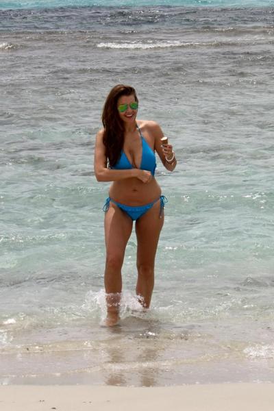 16P Busty Imogen Thomas in blue bikini eating an ice cream on a Spanish beach