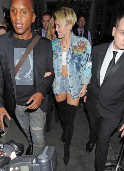 16P Miley Cyrus wearing denim hotpants  fuck-me boots out in London