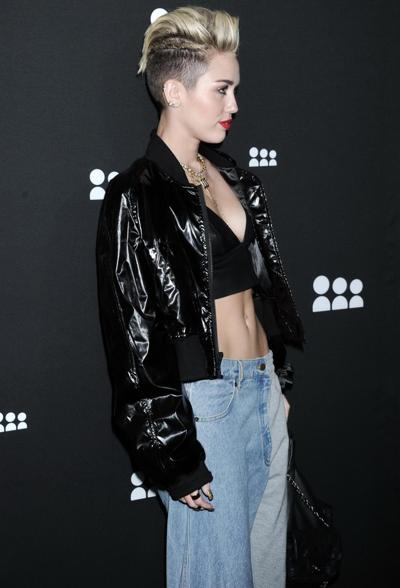 16P Miley Cyrus wearing a leather crop top at the Myspace launch event