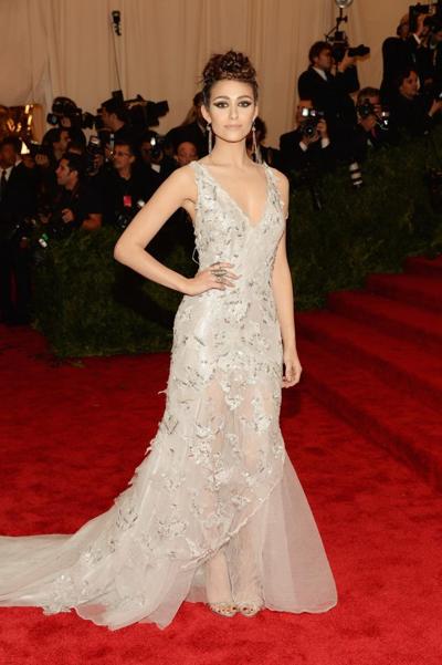 16P Emmy Rossum mostrando un gran escote con un vestido de encaje blanco parcialmente transparente en 2013