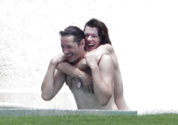 16P Milla Jovovich captada en topless en la piscina por paparazzi y mostrándoles el dedo medio
