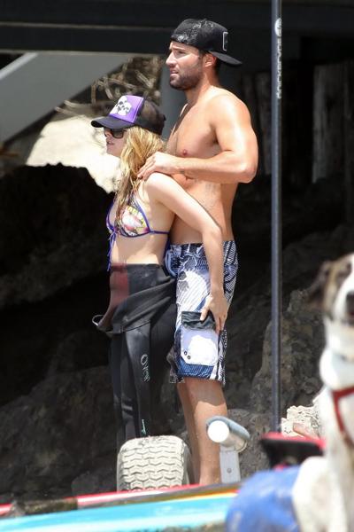 13P Avril Lavigne wearing a bikini top and a wetsuit on the beach in Malibu