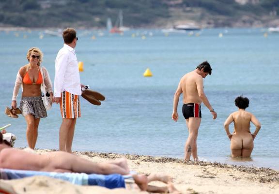 15P Busty Geri Halliwell showing pokies in skimpy orange bikini at Club 55 beach in 