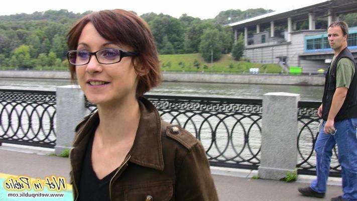 15P Nervöses Grinsen eines Mädchens mit Brille, das in der Öffentlichkeit in Jeans gepisst hat