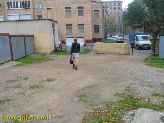 15P Hidden camera photos of a redhead girl having a pee behind a building