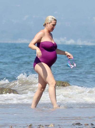 19P Katy Perry grávida em um maiô roxo.